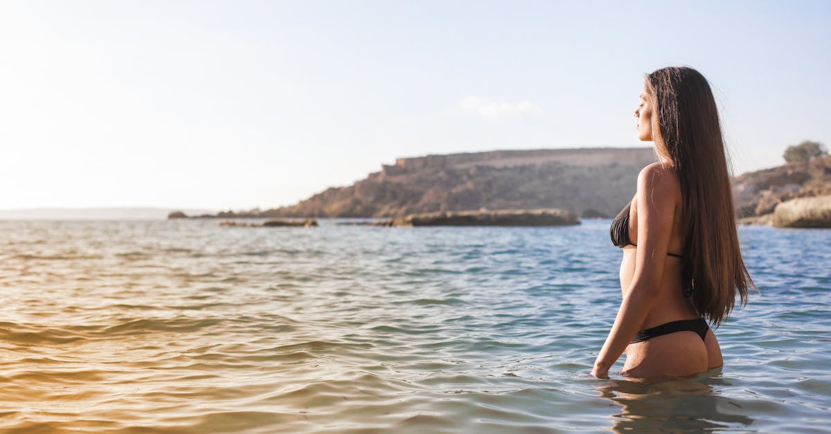 元カノに連絡するか迷いながら夕陽を見つめている男性の後ろ姿