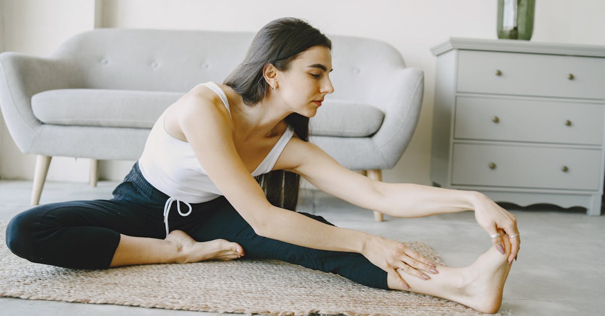 自宅でストレッチをする女性がマットの上でお腹を引き締めるポーズをしている
