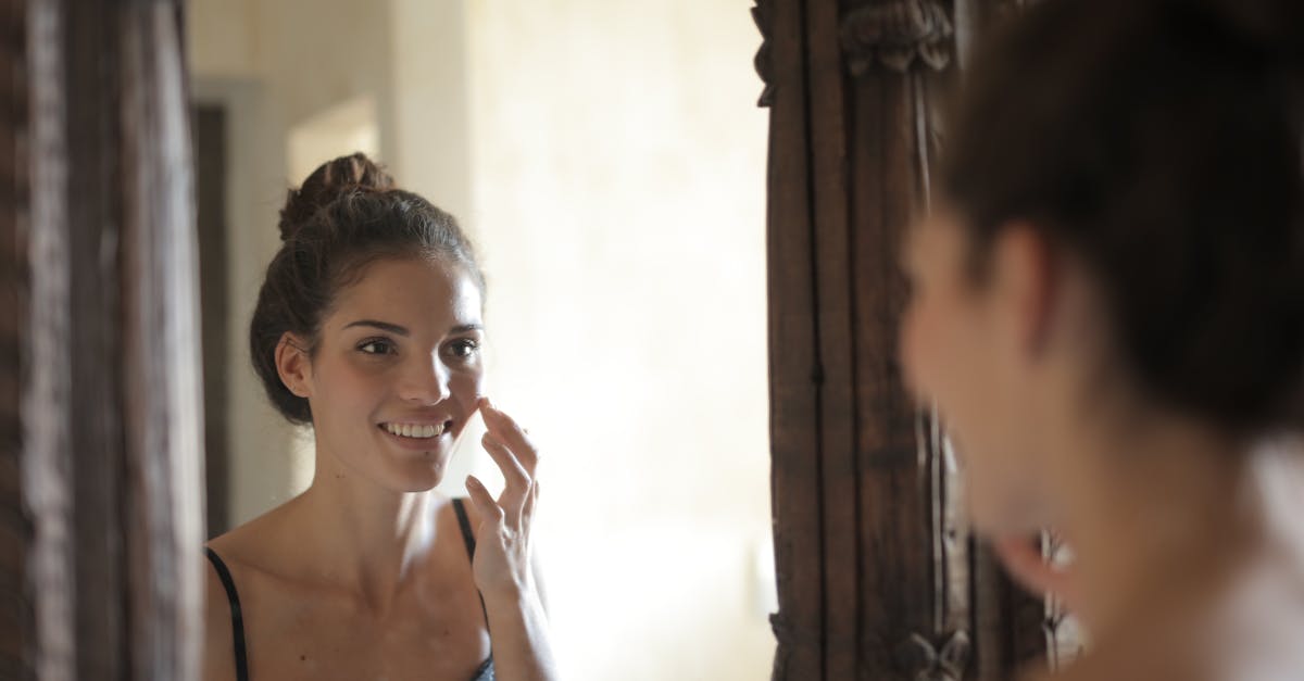 鏡を見て肌のツヤやくすみを気にする女性。自然光の中で素肌を確認するリアルな場面。