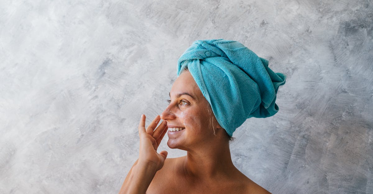 柔らかな笑顔で肌のツヤを見せる大人の女性。自信と幸福感を感じる表情が印象的なビジュアル。