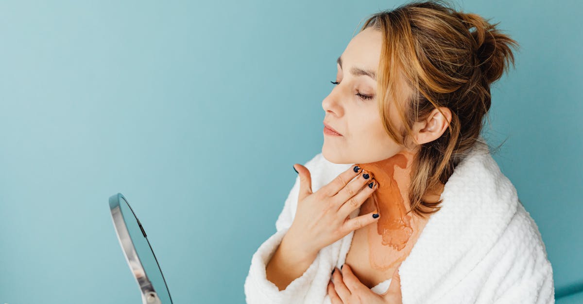 鏡を見て肌のツヤやくすみを気にする女性。自然光の中で素肌を確認するリアルな場面。