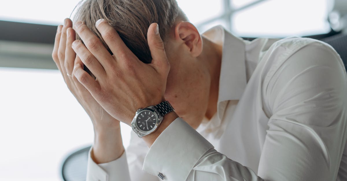 朝起きても疲れが抜けない様子の男性が目覚まし時計を見る場面