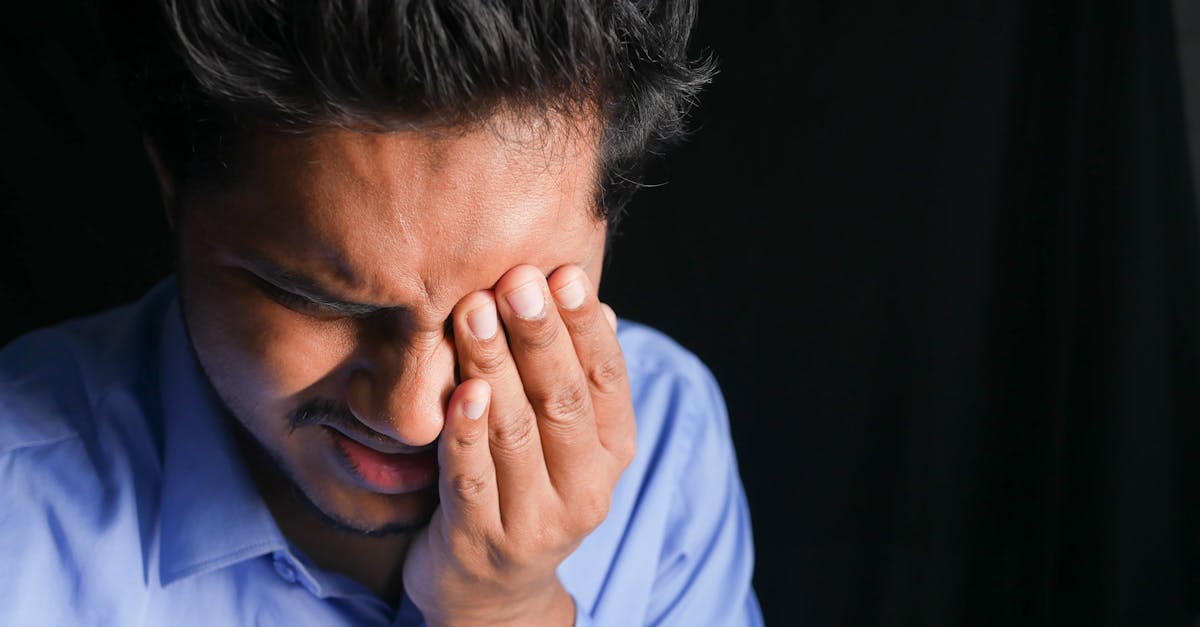 朝起きても疲れが抜けない様子の男性が目覚まし時計を見る場面